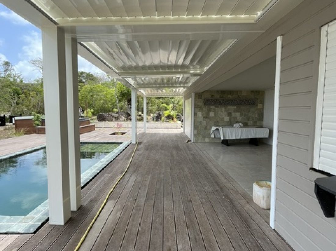 Pergola bioclimatique Nord System éclairée au bord d'une piscine